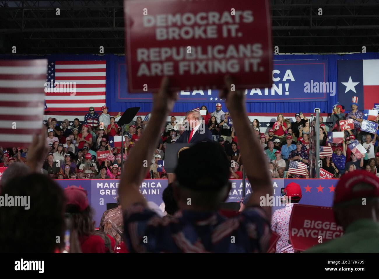 Supporters hold banners as President Donald Trump speaks during a ...