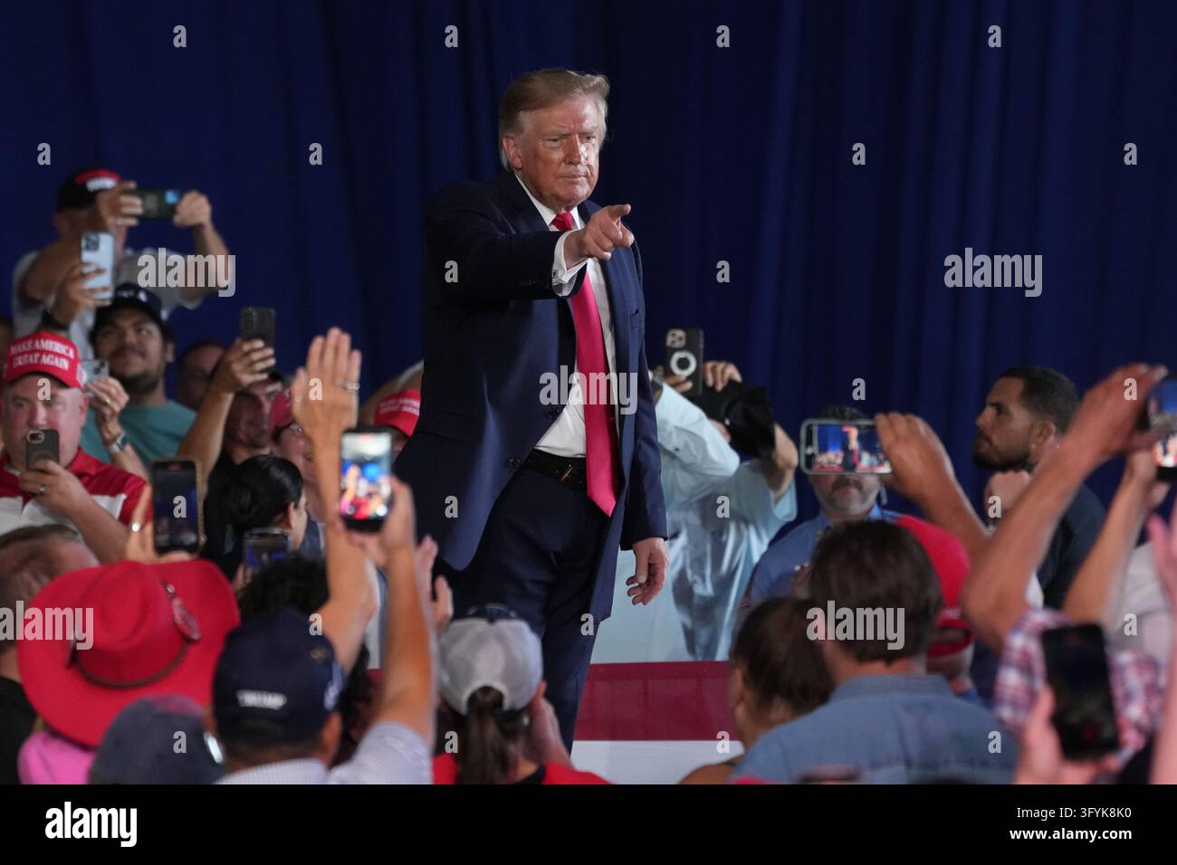 President Donald Trump points to supporters during a campaign rally ...