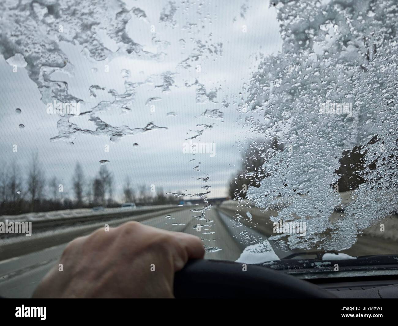 Frozen car windshield covered with ice and snow. Winter weather and ...