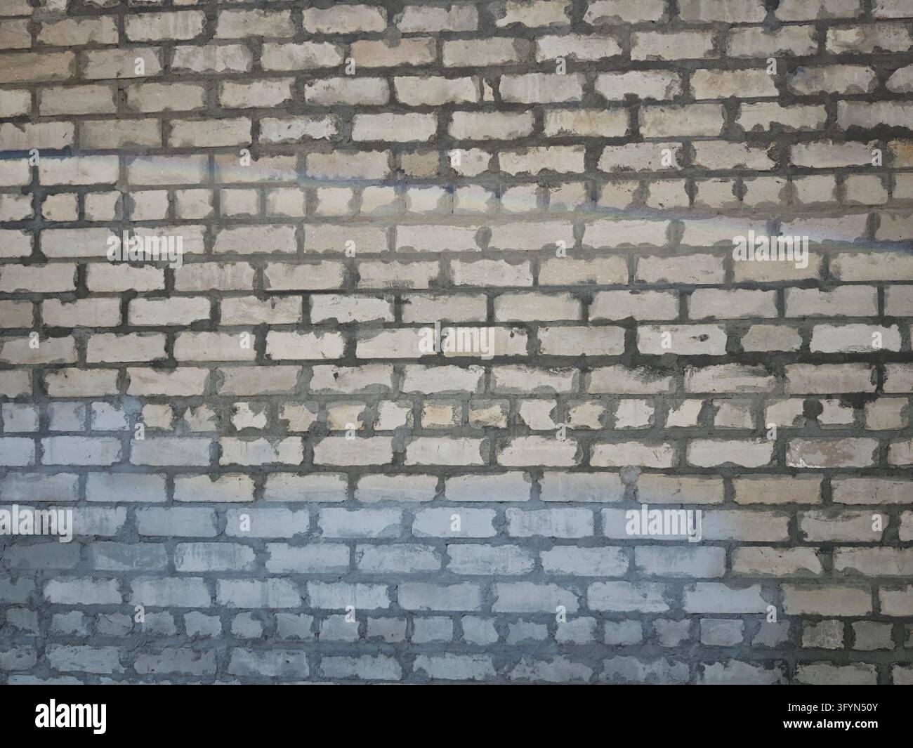 Rough wall displays a pattern of bricks with different colors and ...