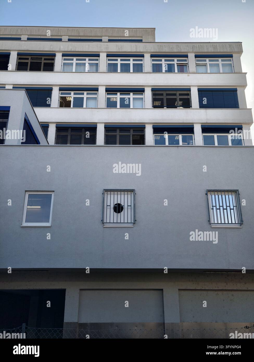 Minimalist urban building facade with repetitive window shutters under ...