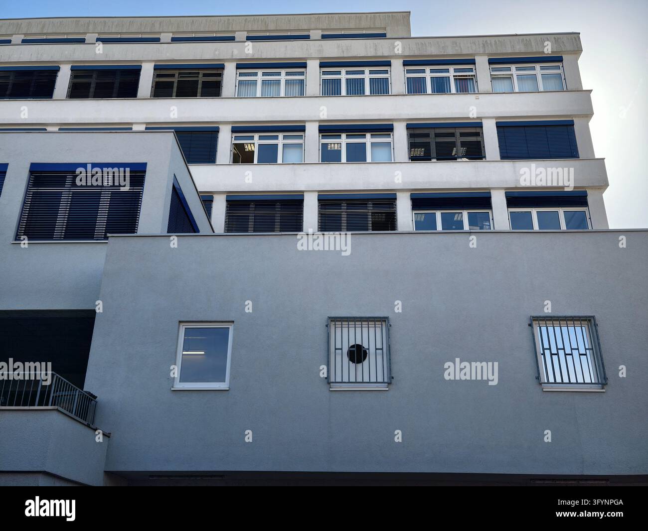 Modern white corporate building facade with horizontal windows and blue ...