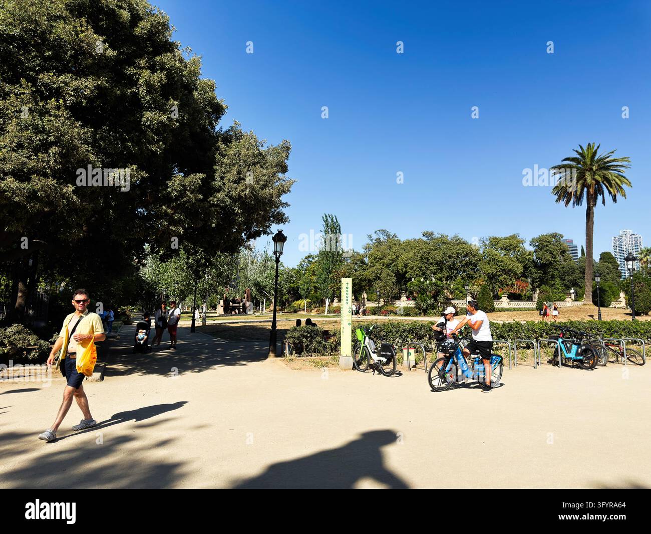 Barcelona , Spain - June 27, 2026: People walk and cycle along a sunny ...