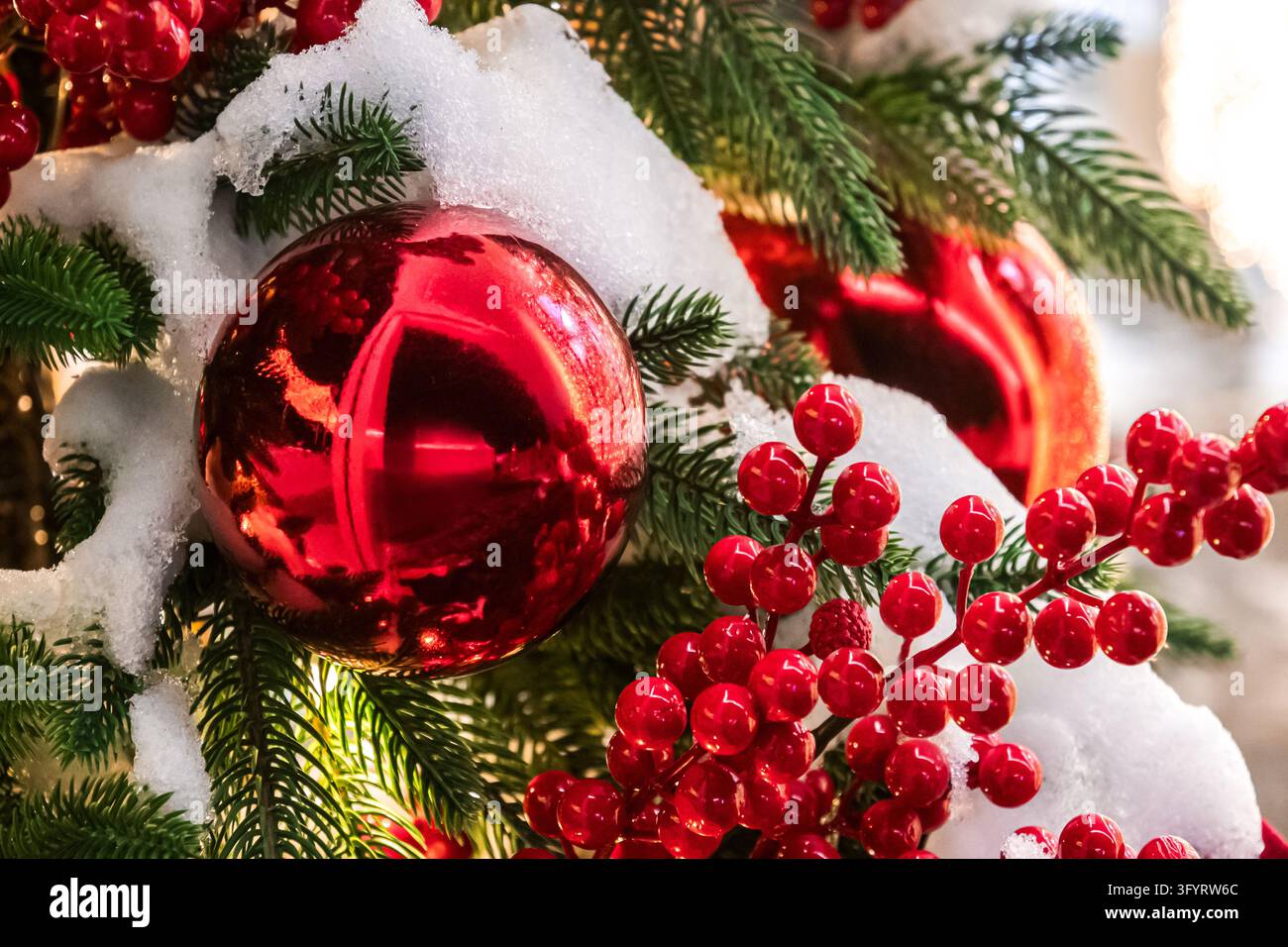 Closeup of a glossy red Christmas bauble surrounded by white snow ...