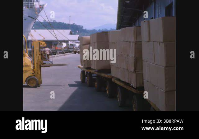 Busy Load USA - 1968 - Trucks are busy loading cargo piles onto the ship ...