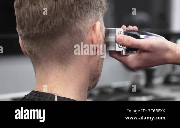 Close up of barbers hands using electric razor, creating precise ...
