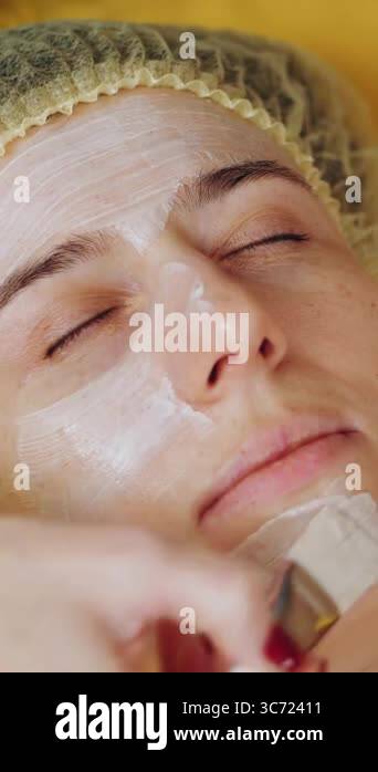 Cosmetology face mask close up woman is lying on couch and getting Cosmetology face mask close up woman is lying on couch and getting