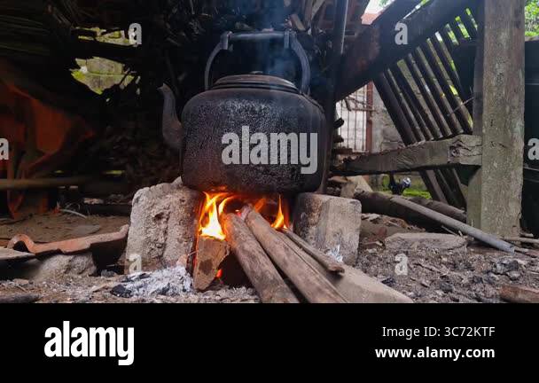 Boiling water using a traditional kettle and stove in the village ...