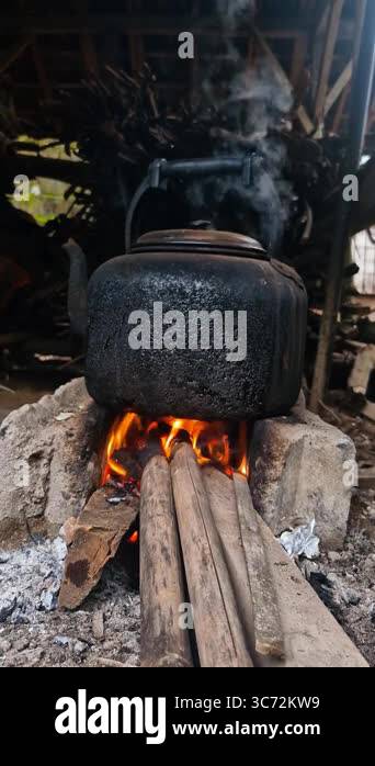 Boiling water using a traditional kettle and stove in the village ...