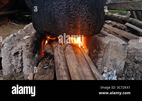 Boiling water using a traditional kettle and stove in the village ...