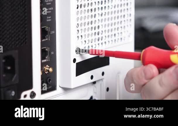 A person secures a screw on a white computer case using a screwdriver ...
