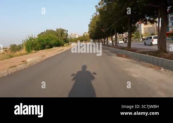 Motorcycle Rider Shadow on Service Road with Moving Traffic and ...