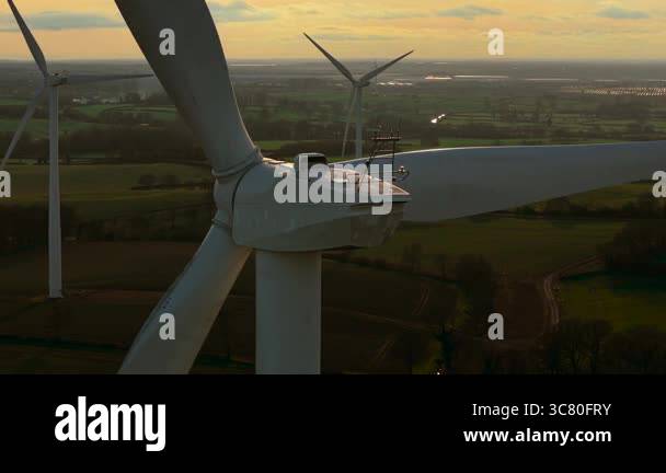 Wind farm in rural field. Wind turbine rotating large rotor blades to ...