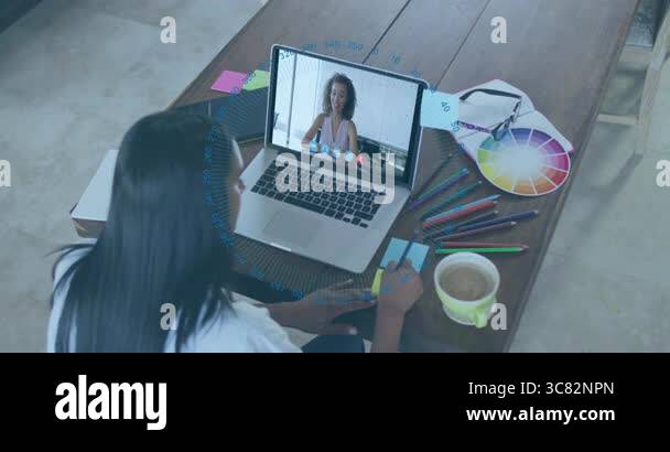 Video chatting on laptop with digital data overlay, woman in home ...