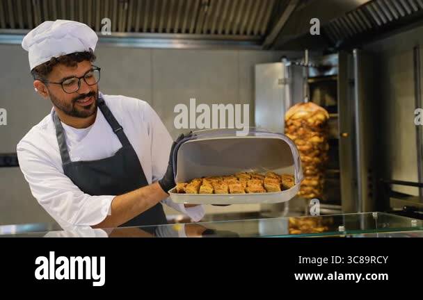 A chef holding a tray of freshly baked biscuits