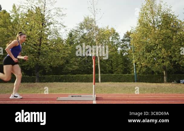 Speed Obstacles Female Athlete is Running Towards an Obstacle, Hurdling, Jumping Over ...