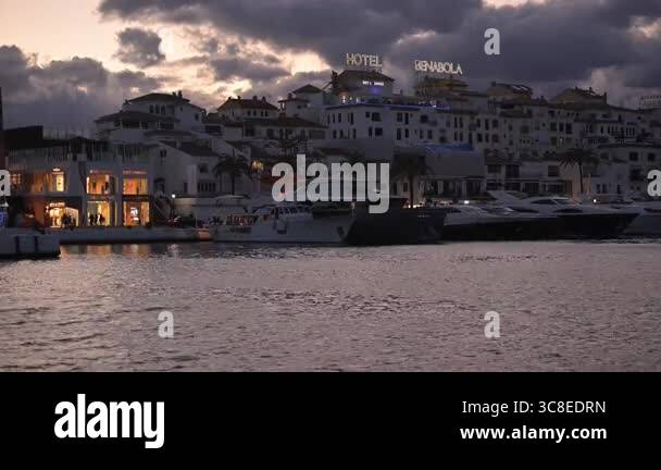 Evening Lights Illuminate The Waterfront As Boats Rest In The Puerto evening-lights-illuminate-the-waterfront-as-boats-rest-in-the-puerto