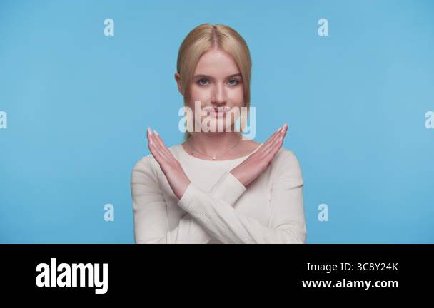 Signaling Poses Young woman in white top poses with arms crossed in front, signaling no ...