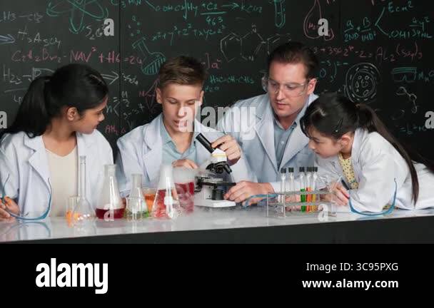 Multicultural student looking under microscope while cute girl inspect ...