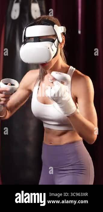 Female boxer training with VR or virtual reality, wearing VR headset ...
