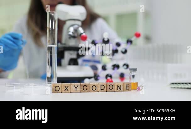 Laboratory technician analyzes Oxycodone with microscope near molecular ...