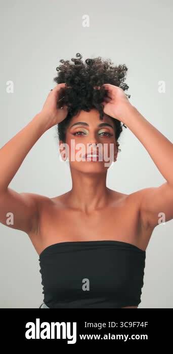 Portrait of a young swarthy woman with curly black hair and bright ...