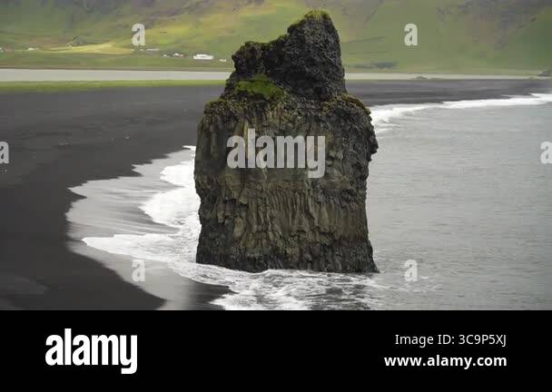 Video shows a striking basalt sea stack rising from the black sand ...
