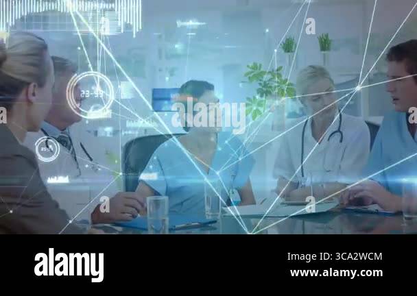 Medical team sitting around glass table reviewing patient data with ...