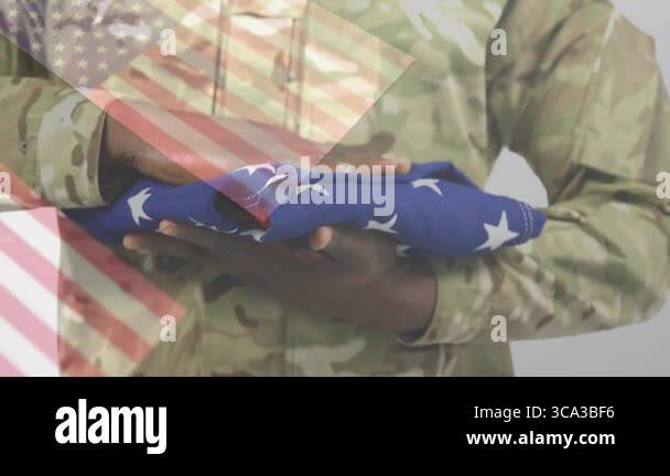 male soldier in camouflage uniform holding folded American flag with ...