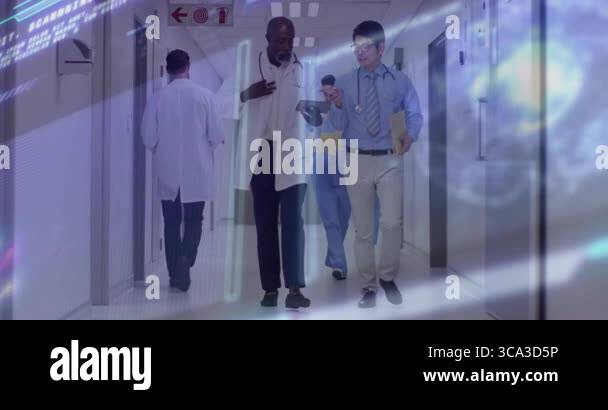 Two doctors walking down hospital corridor, tapping tablet and viewing ...