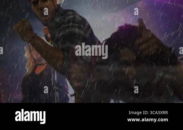 Lead singer shouting under pouring rain on music stage, showing ...
