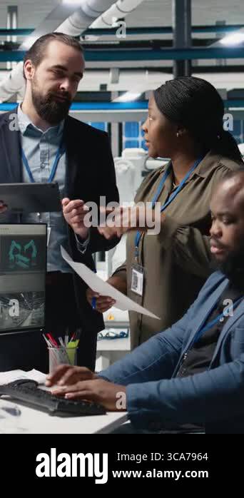 Video Collaboration Engineering Vertical Video Multiethnic master engineers doing teamwork on high tech ...