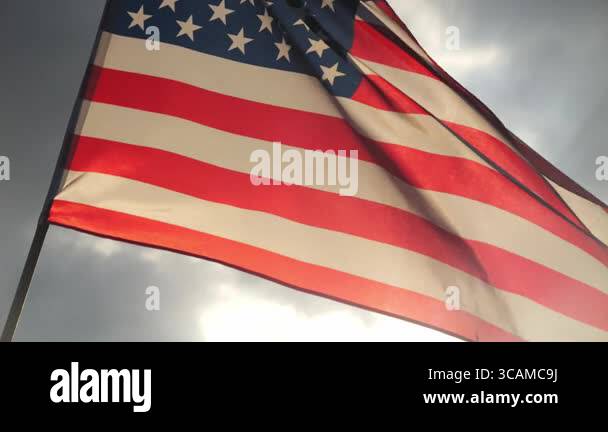 close up American flag waving in the wind against sunset with slow ...