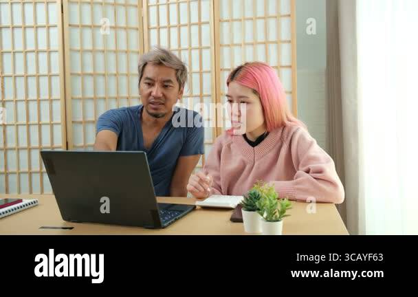 Supportive older brother teaching middle-aged sister how to use laptop ...