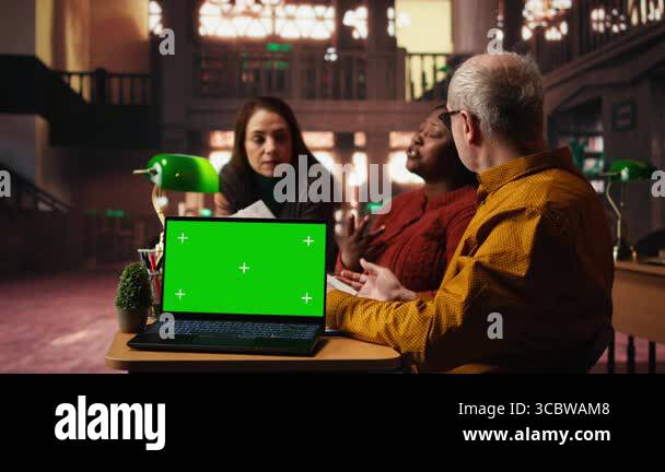 Colleagues practicing script reading in a public library with mockup ...