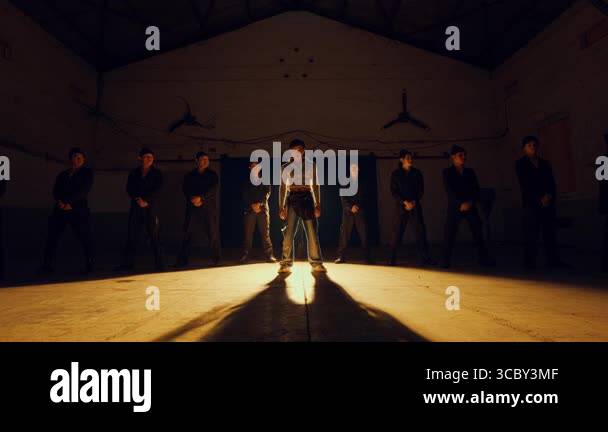 A group of people standing in a dimly lit hall with a spotlight on the ...