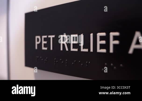 Sign reading PET RELIEF AREA in a pet relief zone. Close-up shows ...
