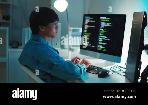 Software developer coding on multiple monitors focused on programming ...