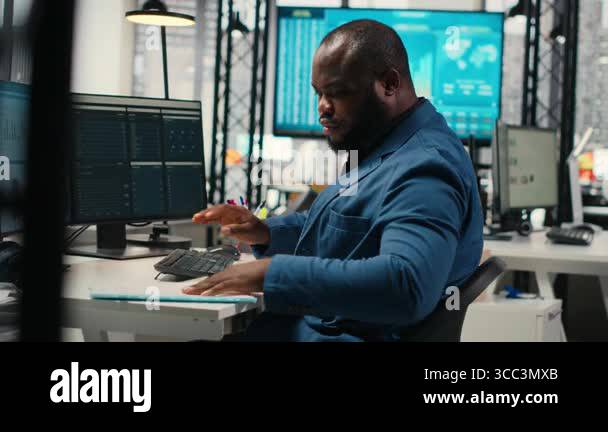 Black male administrator in modern workspace analyzing forecast ...