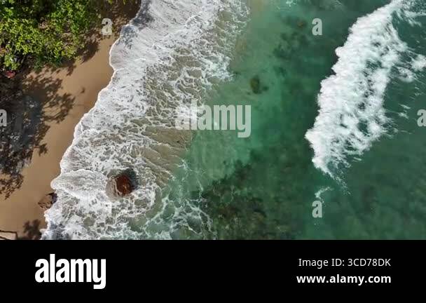 Giant ocean waves crashing and foaming on empty sand tropical beach ...