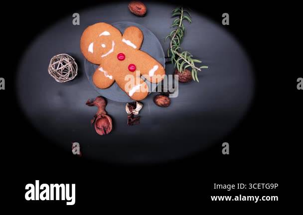 Gingerbread man cookie with icing and candy buttons on black background ...