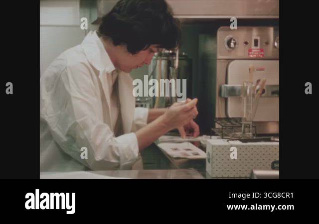 Oak Ridge Experiments OAK RIDGE - 1964 - A scientist prepares slides and looks at them under ...
