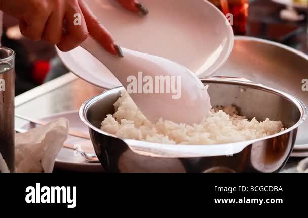 Hands serving rice from pot to plate Stock Video Footage - Alamy