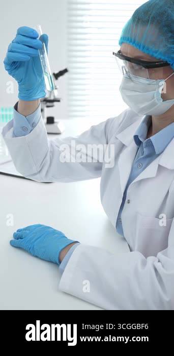 Medical science researcher wearing blue protective gear of cap, gloves ...