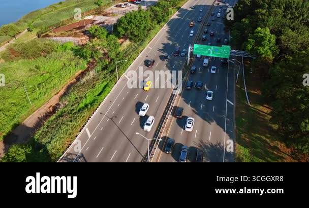 Flying above the multi-lane highway with cars moving to two sides. Busy ...