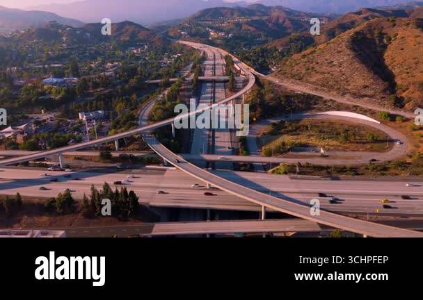 Stunning aerial shot flying backward over a complex freeway interchange ...