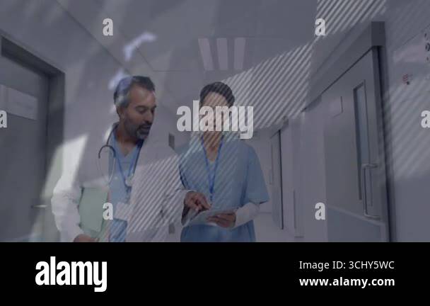 Nurse tapping tablet, doctor walking in corridor reviewing patient data ...