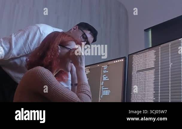 Two developer or programmer colleagues collaborating on programming and ...