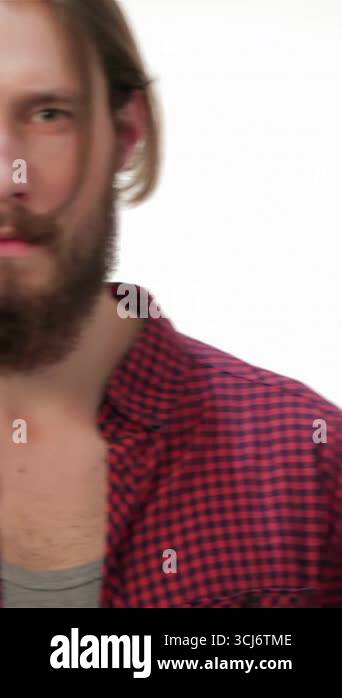 A striking young hipster man with a well-groomed beard and long hair ...