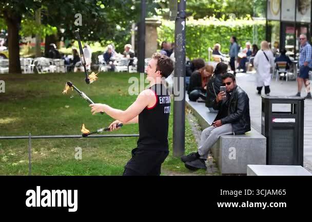 Performer juggling fire sticks in public space Stock Video Footage - Alamy